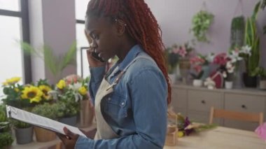 Genç bir kadın telefon etti, elinde parlak bir çiçekçide pano vardı..