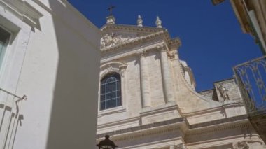 Güzel, güneşli, tarihi, beyaz, taş, kilise, cephe, locorotondo, puglia, İtalya, karmaşık mimarisi ve mavi gökyüzü arkaplanı.