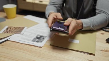 Dedektifin ofisindeki genç bir adam akıllı telefon ve belgelerle kanıtları inceliyor..