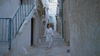 Polignano 'da genç bir İspanyol kadın kısrak, puglia, İtalya, beyaz bir kıyafetle tuhaf Avrupa caddelerinde yürüyor..