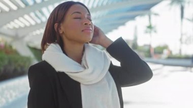 Rahat Afro-Amerikan kadın şehir parkı ortamında güneşin tadını çıkarıyor.