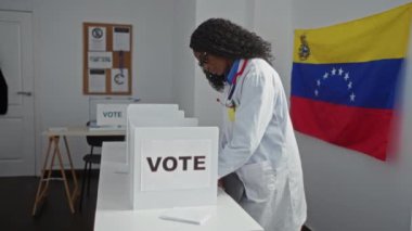 Kıvırcık saçlı güzel bir Afro-Amerikalı kadın, arka planda bir bayrak olan Venezuela seçim odasında oy kullanıyor..