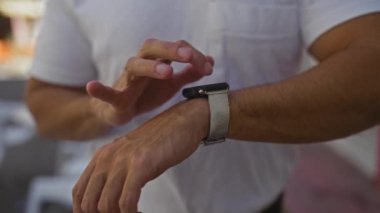 İspanyol bir adam şehir ortamında dışarıda akıllı bir adam kullanıyor, beyaz bir gömlek giyiyor, elleri gündüzleri caddeye odaklanıyor..