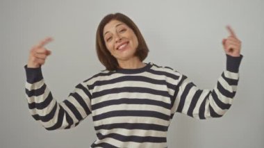 Mutlu, kendine güvenen İspanyol kadın gururla kendini gösteriyor, izole edilmiş beyaz arka planda çizgili süveter giyiyor, gülümsemesinde başarıyı ifade ediyor.