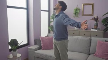 Sakallı bir Arap, oturma odasında bir anlık rahatlıktan zevk alır, rahat dairesinde kendini rahat hisseder..