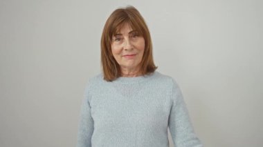 Süveter dalgaları takan neşeli orta yaşlı kadın. Işıl ışıl bir gülümsemeyle merhaba diyor. Sıcak, dostça karşılıyor. İzole edilmiş beyaz bir arkaplan karşısında duran kendine güveni....