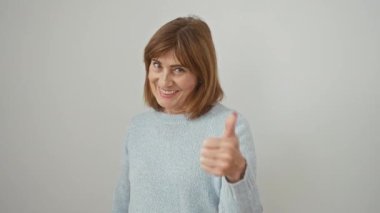 Orta yaşlı, süveter giyen İspanyol kadın elleriyle mutlu bir jest yapıyor. Kameraya bakıp başarıyı gösteren ifadeyi onaylamak. izole edilmiş beyaz arkaplan