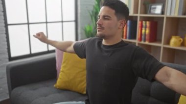 Rahat bir genç adam rahat bir oturma odasında gri bir kanepeye uzanıyor, rahatlık ve refahı ifade ediyor..