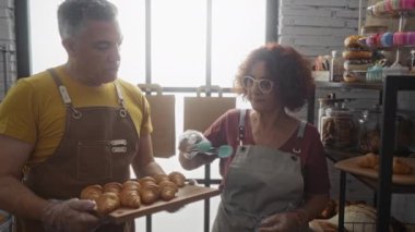 Erkek ve kadın bir pastanede birlikte pasta hazırlıyor profesyonel bir ortamda.