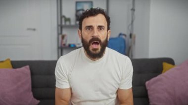 Orta yaşlı, şok olmuş ve korkmuş bir adam, beyaz bir tişört giyiyor, şaşkın yüzü tamamen panik içinde, inançsızlık ve korku belirtileri, şaşırtıcı bir şok ifadesi!