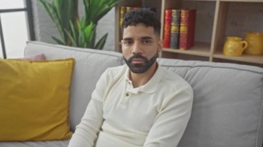 Evdeki İspanyol genç adam avuç içi hareketlerini durdurdu. Ciddi bir uyarı ifadesi ve olumsuz bir yüz ifadesi sergiliyor.