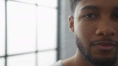 Gülümseyen bir Afro-Amerikan 'ın yakın plan portresi. Kapalı alanda, yumuşak odaklı arka plan ve gün ışığında.