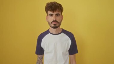 Genç İspanyol adam başarıyı kutluyor, kazanan olarak duruyor, kollarını neşe içinde zafere açıyor. Evet zafere, izole edilmiş sarı arka plana.