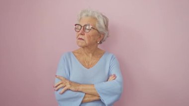 Gri saçlı, son sınıf öğrencisi, şüpheli ama kendine güvenen, onaylamayan bir bakışla kaşlarını çatan. Olumsuz duygular gergin suratlarda belirdi, pembe izole edilmiş arka planda çapraz kollarla duruyordu..