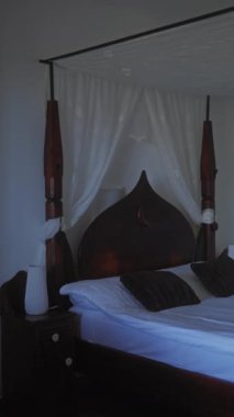 Kubbeli yatak odası, ahşap yatak başlığı, beyaz çarşaflar ve lüks bir otel ortamında peluş yastıklar.