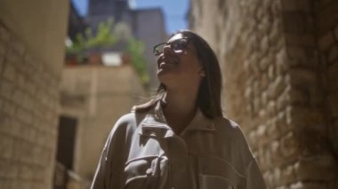 Güzel, genç, İspanyol bir kadın. Bari, puglia, İtalya 'da eski sevimli caddeleri keşfediyor. Tarihi taş binalarda sırılsıklam oluyor ve güneşli havanın tadını çıkarıyor..