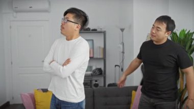 Modern bir oturma odasında sarılan iki Asyalı adam.