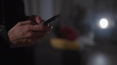 Kapalı bir suç mahallinde bir dedektifin elinde akıllı bir telefon varken yakın plan çekilmiş.