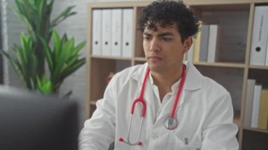 Beyaz bir klinik odasında boynunu tutarak acı çeken genç bir İspanyol erkek doktor..