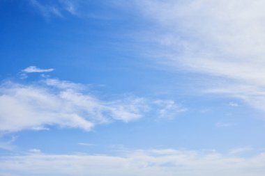 Pofuduk beyaz bulutlarla dolu canlı mavi gökyüzü geniş sakin arkaplan boyunca yayılıyor, arka plan veya doğa temaları için ideal..