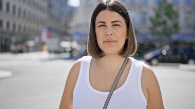 Viyana sokaklarında ciddi bir ifadeyle duran genç, güzel İspanyol kadın.