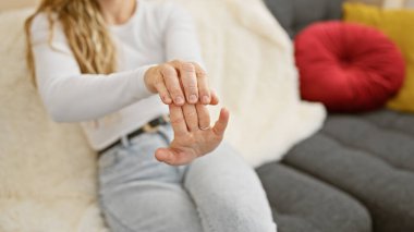 Rahat bir ev ortamında parmaklarını uzatan genç bir kadın, refahını ve günlük yaşamını gösteriyor..