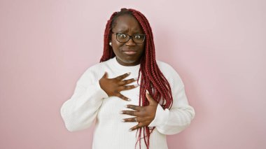 African american woman with braids wearing glasses and a white sweater against a pink background. clipart