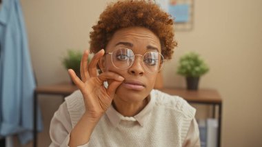 Siyahi kadın sessiz ev içi gözlükleriyle el kol hareketi yapıyor.