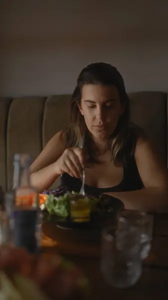 stock image A young hispanic woman enjoys a healthy meal at a modern restaurant, showcasing dining and lifestyle.