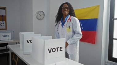 Kıvırcık saçlı güzel siyah bir kadın Venezuela seçim odasında duruyor ve oy verirken gülümsüyor..