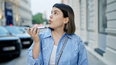 Genç ve güzel İspanyol kadın Viyana sokaklarında akıllı telefonuyla sesli mesaj gönderiyor.