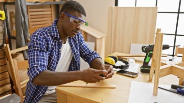 Bir marangoz atölyesinde özenle çalışan yetenekli bir Afrikalı Amerikalı..