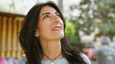 Düşünceli bir İspanyol son sınıf öğrencisi, yemyeşil bir bahçede sakin bir anın tadını çıkararak olgunluğunu ve neşesini ön plana çıkarıyor..