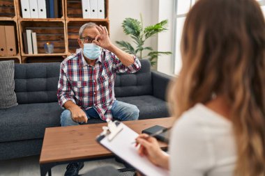 Psikoloji kliniğinde maskeli neşeli bir son sınıf öğrencisi, güvenle gülümseyen gözlerle işaret veriyor. Ne kadar olumlu bir manzara.!