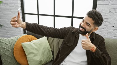 Neşeli bir adam, şık bir oturma odasında selfie çekmekten zevk alır..