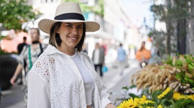 Stockholm sokaklarında kendinden emin gülümseyen genç, güzel İspanyol kadın.