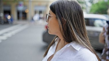 Madrid sokaklarına bakan, gözlüklü, güzel İspanyol bir kadın.