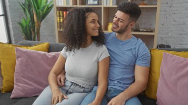 Sevgi dolu bir çift, bir erkek ve bir kadın, renkli yastıkları olan bir kanepede birlikte rahatlar, samimiyet ve samimiyet yayarlar..