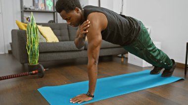 Modern bir oturma odasında yoga minderinde şınav çeken sağlıklı bir yaşam tarzı ve ev egzersizi geliştiren fit bir adam..