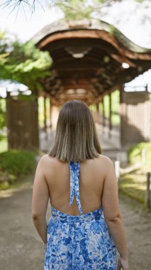 Çekip giden güzel bir İspanyol kadının portresi, Hian Jingu 'da sıradan bir yürüyüşün arka planı, Kyoto' nun geleneksel Japon tapınağı.