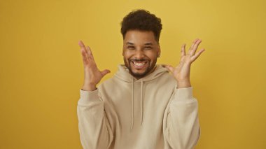 Sarı arka planda gülümseyen mutlu Afro-Amerikalı adam pozitifliği ve neşeli tavırları tasvir ediyor..