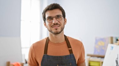 Bir sanat stüdyosunda sakallı, gözlüklü ve önlüklü yakışıklı bir İspanyol 'un portresi..