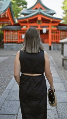 Güzel esmer, gözlüklü, esmer bir kadın, Fushimi inari-taisha 'da gündelik bir yürüyüşe çıkıyor, Japonya' nın kutsal kyoto türbesi, sırtına çarpıcı bir bakış açısı.