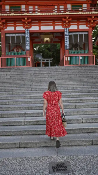 Güzel bir İspanyol kadının arkadan görünüşü, sıradan bir şekilde aşağıya, Kyoto, Japonya 'da geleneksel bir Japon tapınağı olan Yasaka Tapınağı' na iniyor.