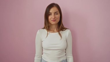 Sarışın, kolları çapraz duran genç bir kadın izole pembe arka planda, mutlu bir şekilde gülümsüyor ve pozitif görünüyor.