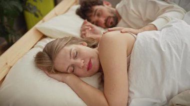 Sevgi dolu bir erkek ve kadın, yatak odasının huzurlu ve özel ortamında rahat ve sevgi dolu bir an sergiliyor..