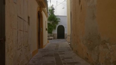 Gelibolu, puglia, İtalya 'da dar bir kaldırım yolu. Eski binalar, kemerli kapılar ve yemyeşil alanlar..