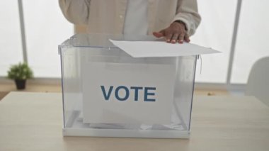 Afrika kökenli Amerikalı bir adam kapalı bir oy kullanma odasında oy kullanırken demokratik oy verme sürecini ve sivil çatışmaların önemini vurguladı..