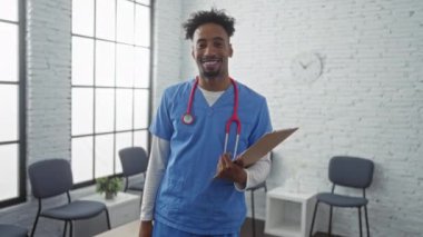 Doktor başarıyı kutluyor. Üniformalı mutlu Afro-Amerikan adam klinik bekleme odasında ifadesini kazanan bir pano tutuyor.