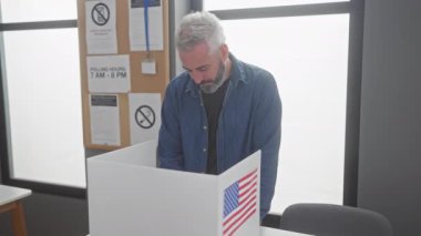 Olgun sakallı adam Amerikan seçim okulunda bayrak sallıyor..